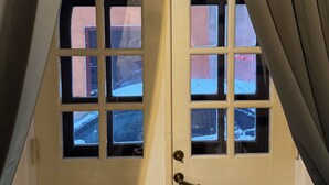 Una puerta doble con seis ventanas, un pomo de latón y un marco blanco.
