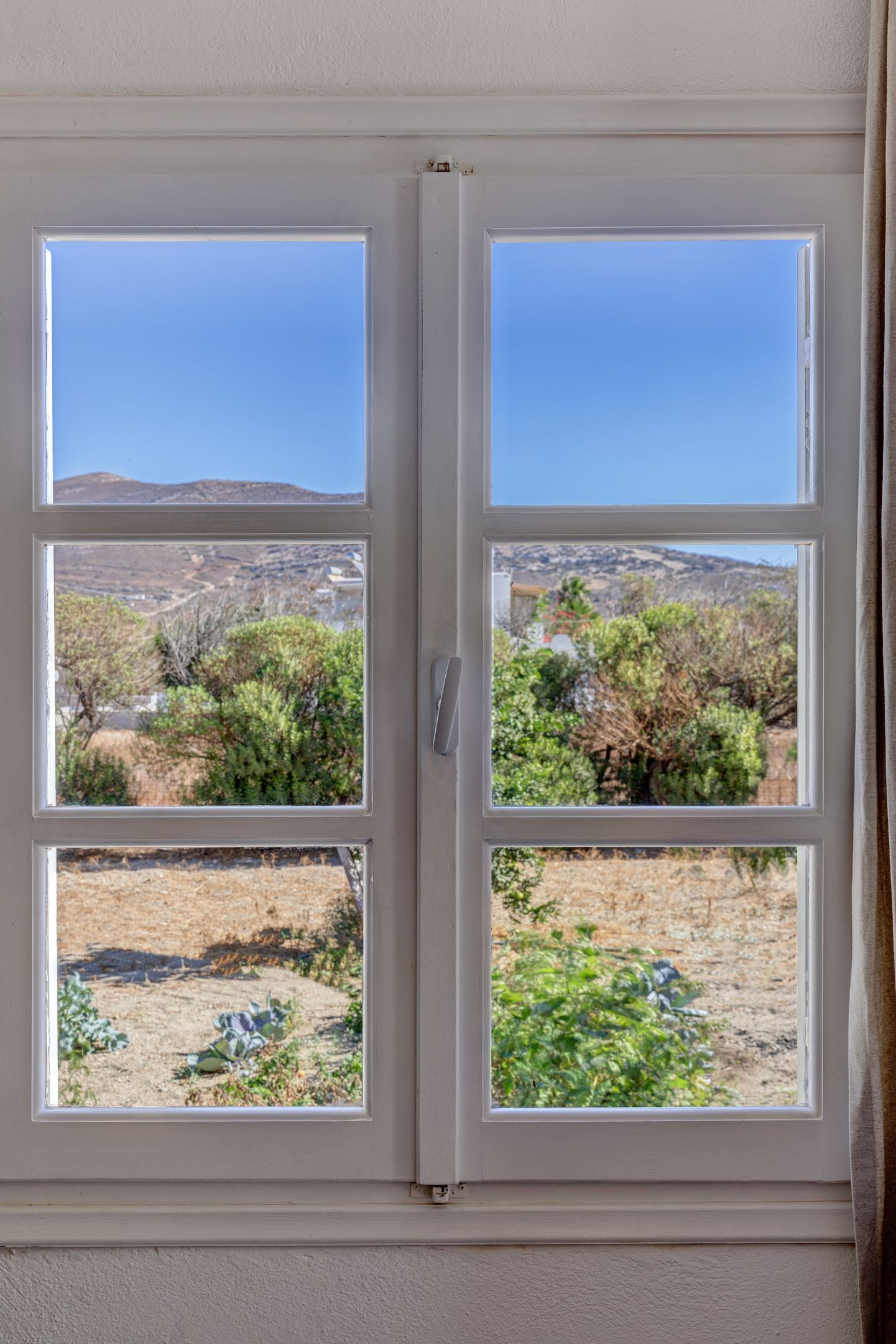 Una ventana con cuatro cristales, cada uno mostrando una vista distinta del paisaje.