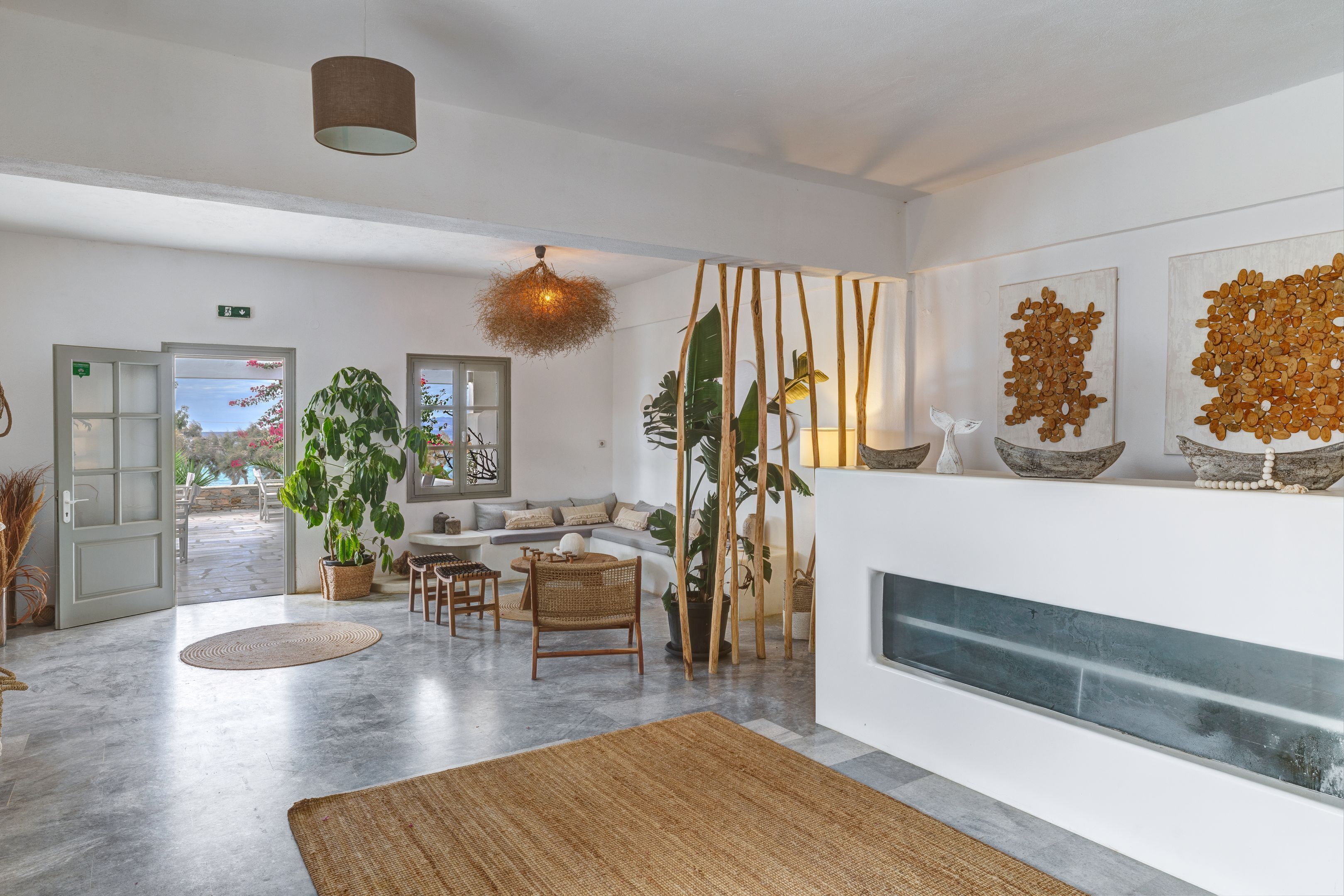 Un hall espacioso con diseño moderno, que incluye una zona de estar, un ventanal grande y una pared decorativa.