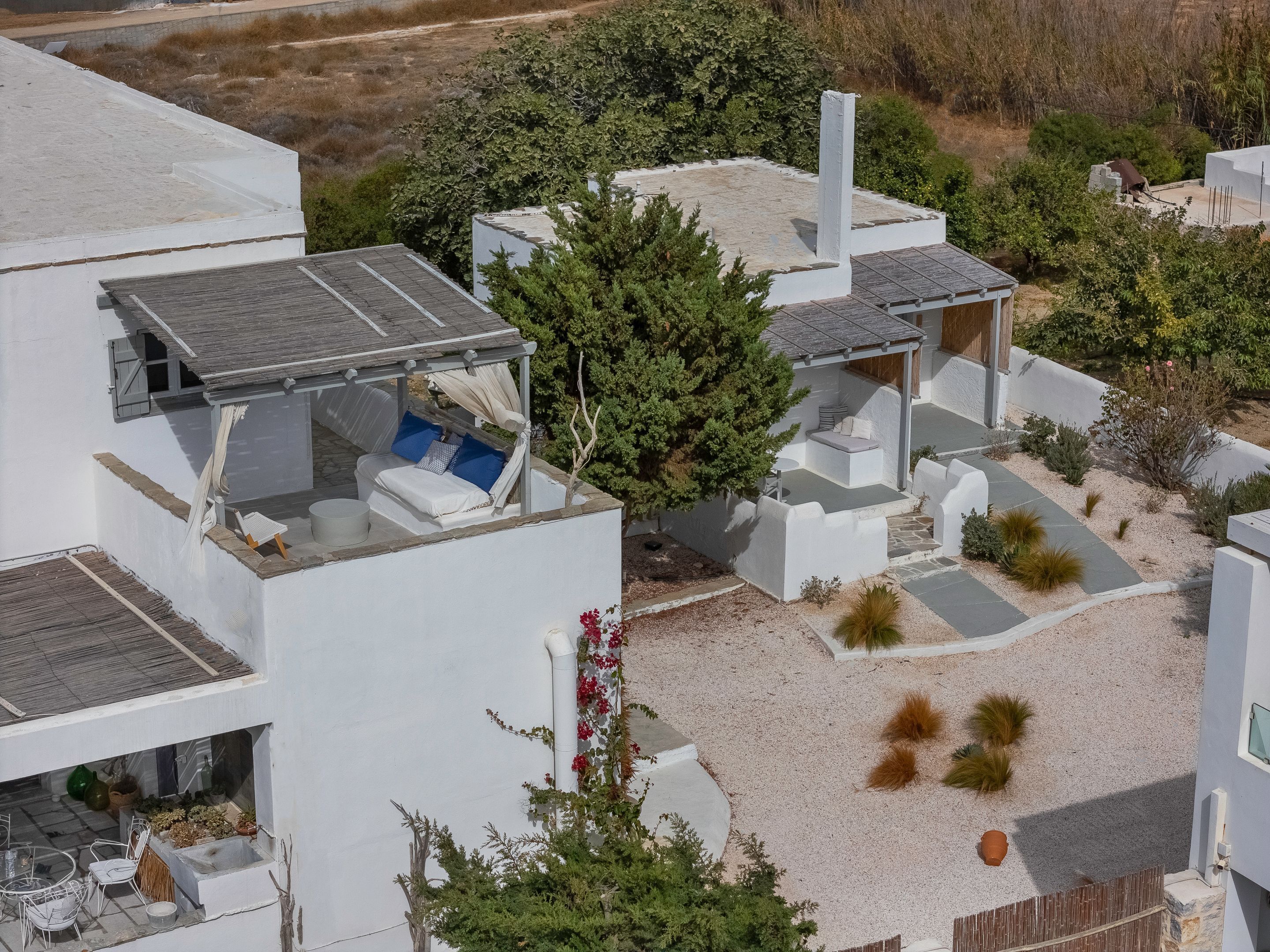 A modern house with a rooftop deck, outdoor seating, and a garden area.