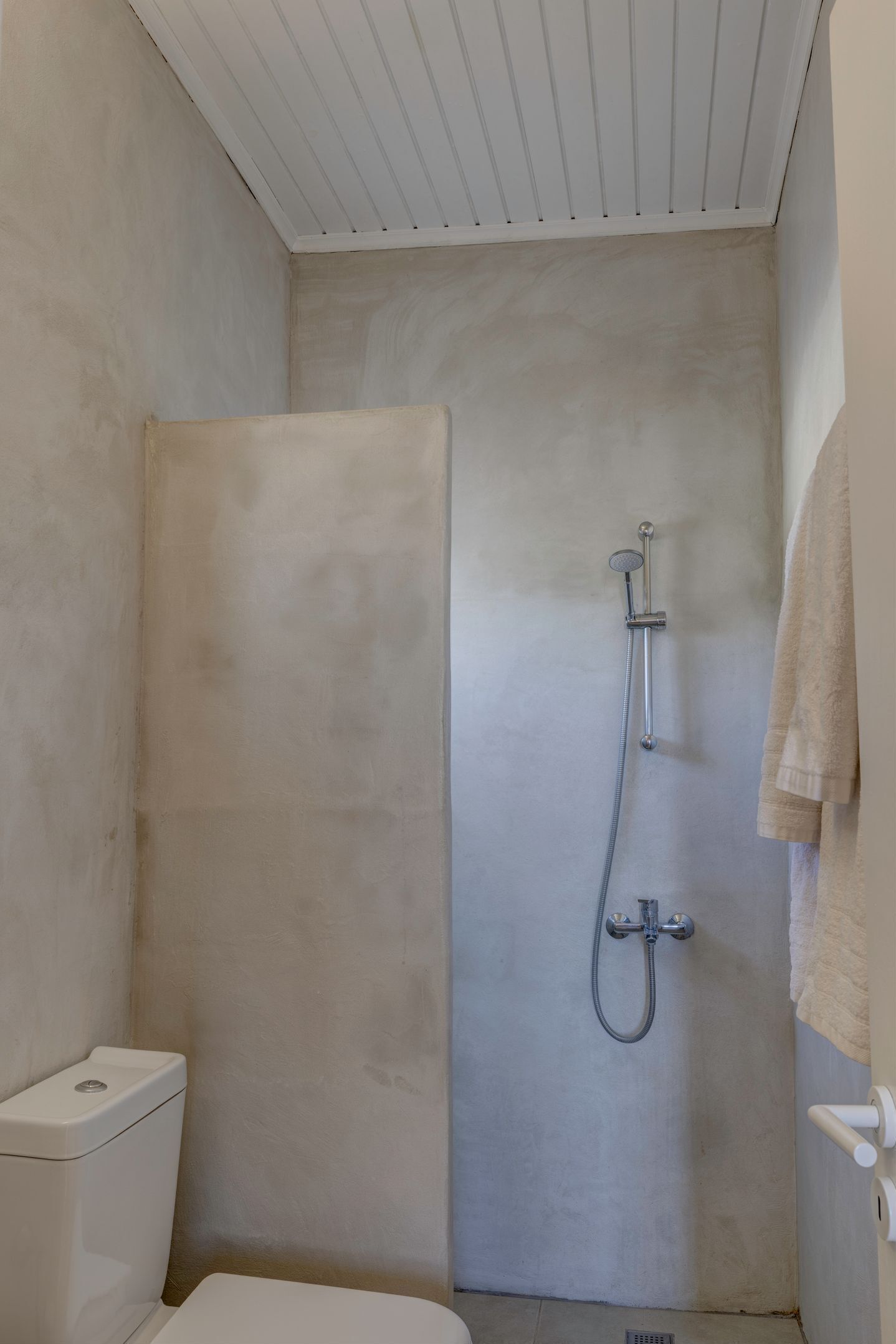 Un bagno con doccia, WC e porta asciugamani.