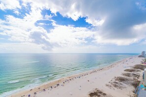 A beach with a sandy shore, a clear sky, and a calm sea. - San Carlos 1905 (Gulf Shores)