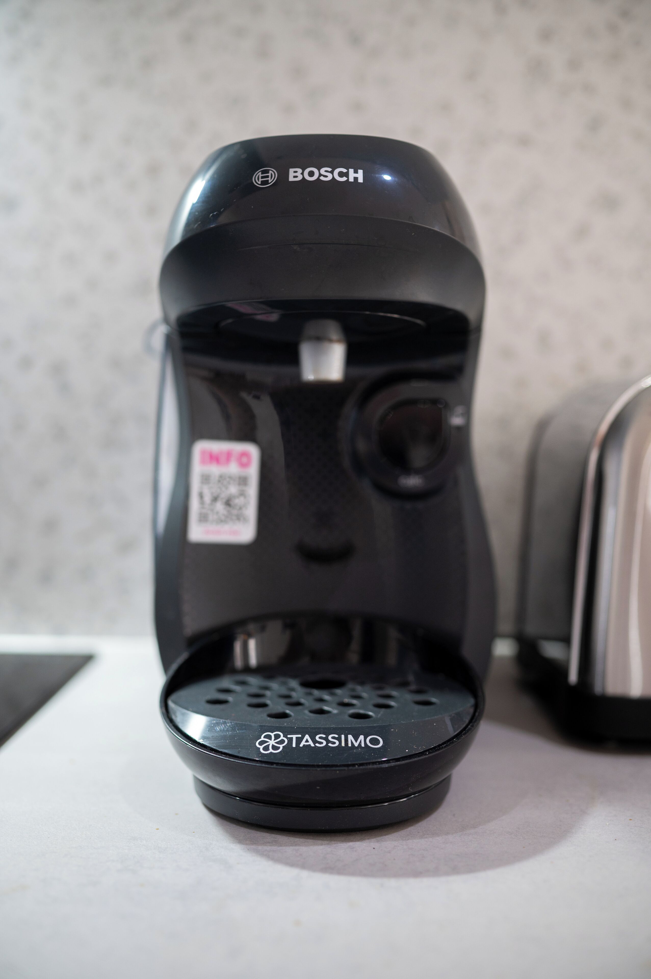 Eine schwarze Bosch-Kaffeemaschine mit einem QR-Code an der Seite, auf einer Arbeitsplatte platziert.