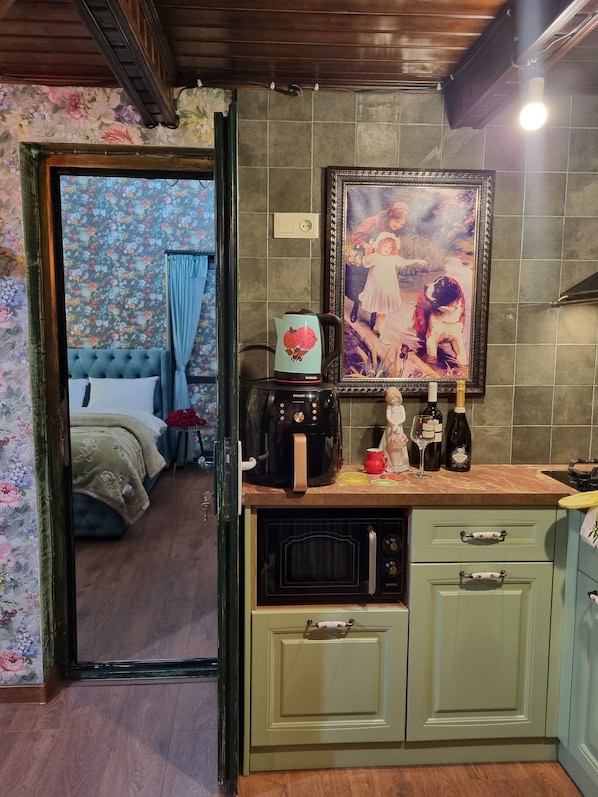 A kitchen with a coffee maker, a framed picture, and a sink.