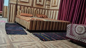 Um quarto com uma cama, um sofá e um tapete estampado.