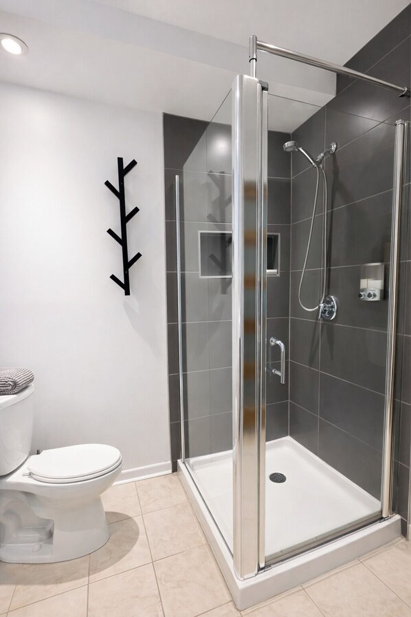 A modern bathroom with a glass-enclosed shower, a toilet, and a towel rack. - BELANSKI | Luxury Condo - Price per Season (Beaupré)