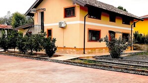A two-story building with a tiled roof, a balcony, and a small garden area with a pathway. - Casa Happy ⚠️1 to 6 guests⚠️ detached attic: 2 bedrooms + 2 bathrooms + parking  (Belpasso)