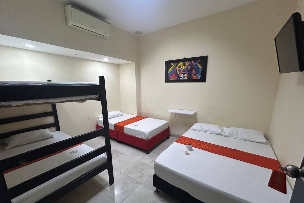 Habitación de hotel con literas, una cama individual, un cuadro en la pared y una ventana.