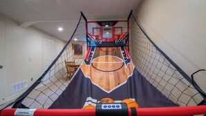 Una cancha de baloncesto con aro, red y una silla.