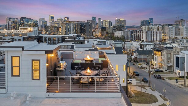 A rooftop terrace with a fire pit, seating, and a city skyline view. - Above the Gulch • Rooftop Fire Pit • Skyline Views (Nashville)