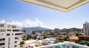 A residential area with modern buildings, a pool, and mountains in the background. - Neos Apartment – Near the Sea by SOHO – 297A (Santa Marta)