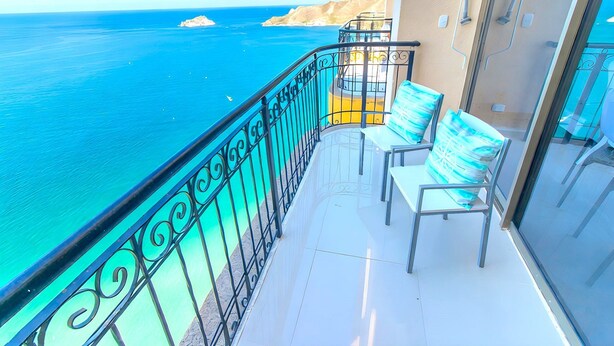 A balcony with a view of the sea, a chair, and a table. - Peñón Rodadero Apartment Oceanfront by SOHO – 263A (Santa Marta)