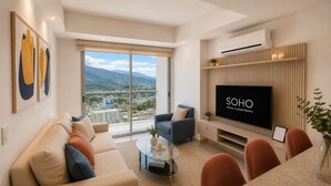 A modern living room with a sofa, armchairs, a glass coffee table, and a TV. - Ambar Roca Apartment – Near the Sea by SOHO – 353A (Santa Marta)
