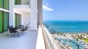Ein Balkon mit Blick auf den Ozean und einen Poolbereich.