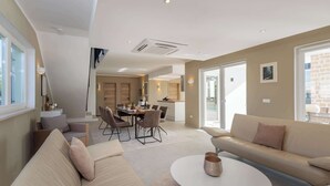Ein modernes Wohnzimmer mit einer Couch, einem Esstisch und einem Couchtisch.