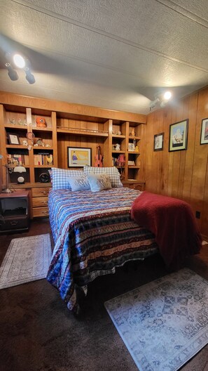 A bedroom with a bed, a red throw blanket, a wooden bookshelf, and a rug. - 4-bedroom country house, AC, Close to Ohio University, Ohio Windy 9, Lg garage (Athens)