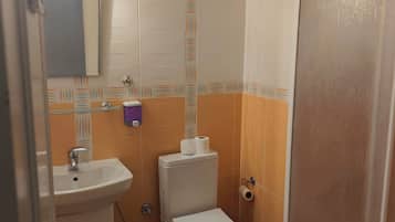 Een bad/douchecombinatie, een haardroger, handdoeken, zeep