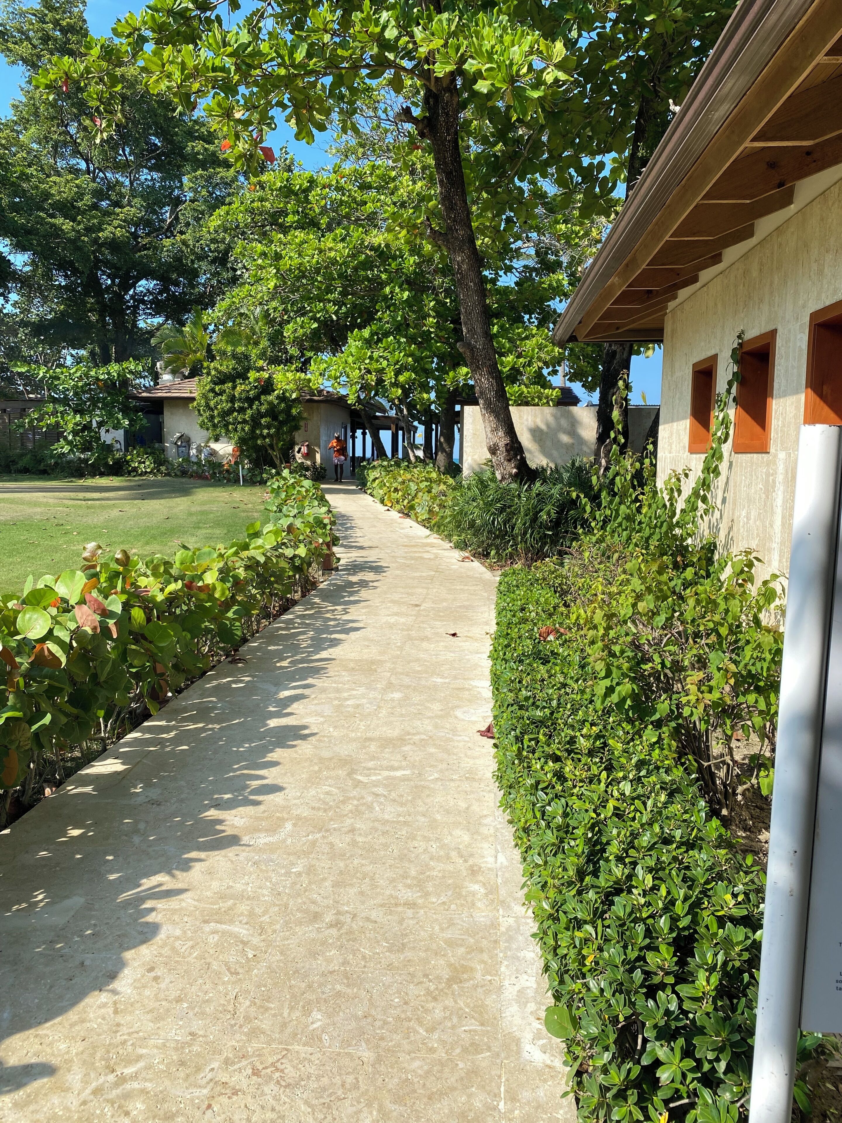 A pathway leading to a building with a covered porch area.