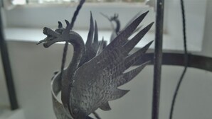 Une sculpture en métal représentant un oiseau aux ailes déployées.