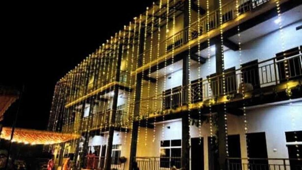 Un edificio de varios pisos con balcones y una alfombra roja que conduce a la entrada.