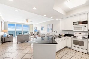 A modern kitchen with white cabinets, a black countertop island, and a large oven. - San Carlos 1905 |Beach Front (Gulf Shores)