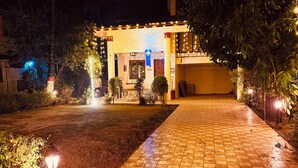 Un edificio con un camino de baldosas a cuadros que lleva a una puerta con un farol azul encima.