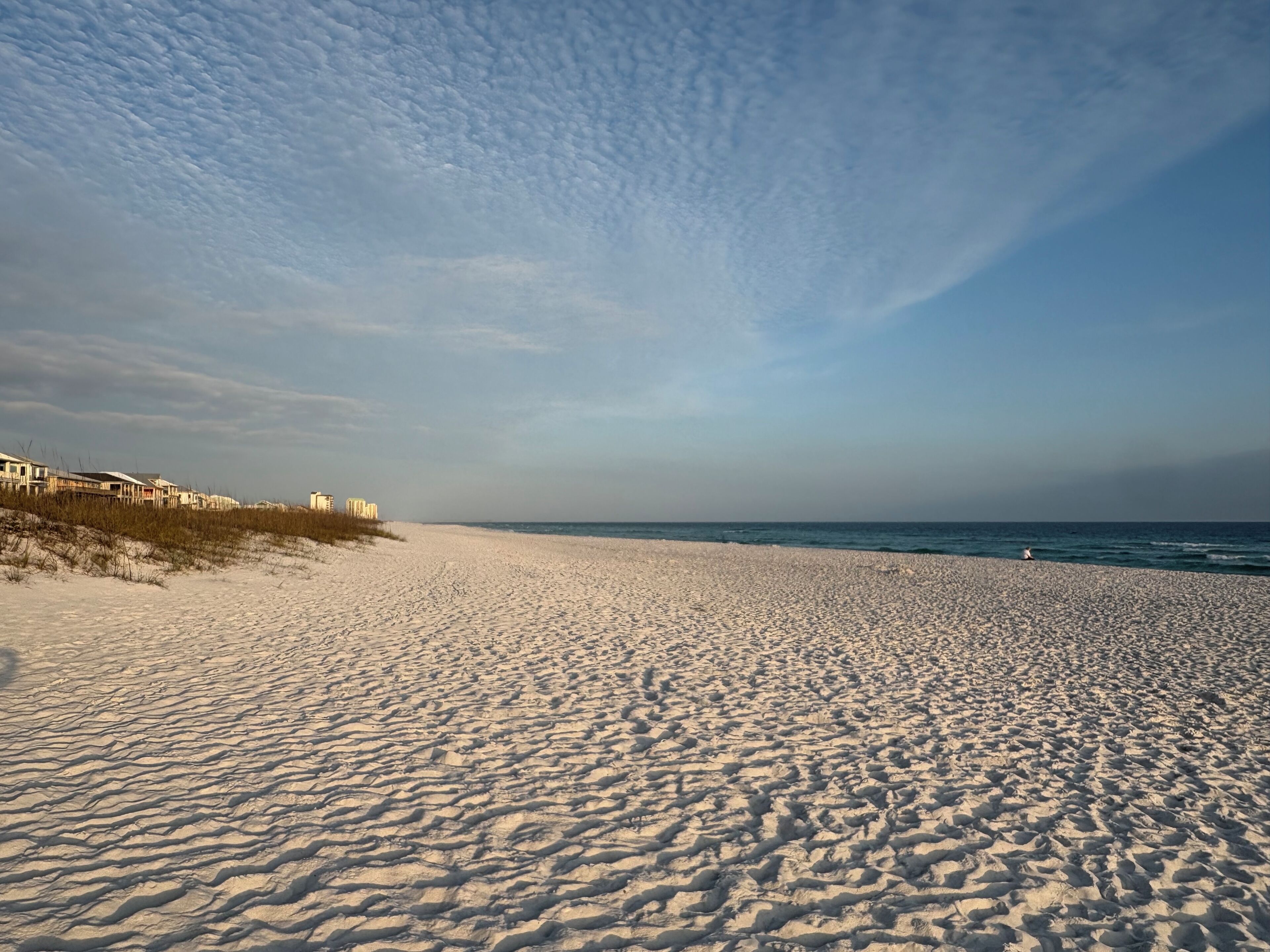A wide sandy beach with a clear sky.