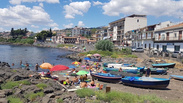 A coastal town with a rocky beach, boats, and people enjoying the water. - Villa Muse Holiday oasis by the sea of CapoMulini-Acireale Holiday Rental (Capo Mulini)