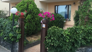A multi-story building with balconies, potted plants, and a stone wall. - Villa Muse Holiday oasis by the sea of CapoMulini-Acireale Holiday Rental (Capo Mulini)