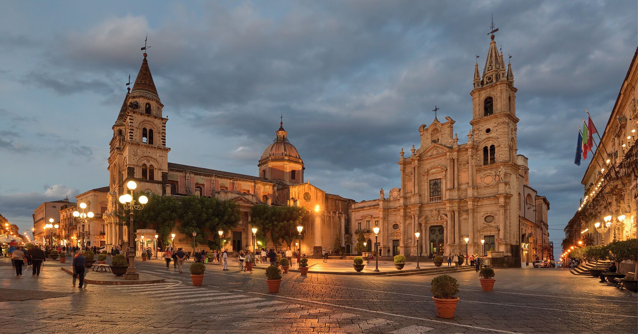 A historic square with ornate buildings, including a prominent church with a bell tower and a dome.