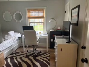 A bedroom with a bed, a desk, a chair, a TV, and a window with blinds. - Quail Hollow PGA Truist: Family home near club (Charlotte)