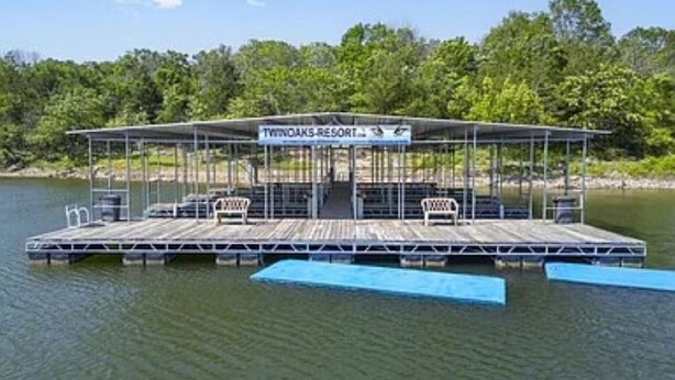 A floating platform with a covered seating area, a sign reading "THINOAKS RESORT," and a dock extending into a body of water. - Deluxe Studio (Branson West)