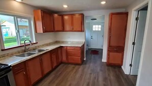 A kitchen with wooden cabinets, a countertop, and a sink.