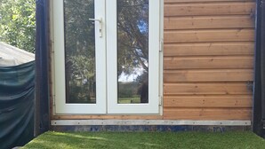 Eine Außenwand aus Holz mit einer Schiebeglasdoor.