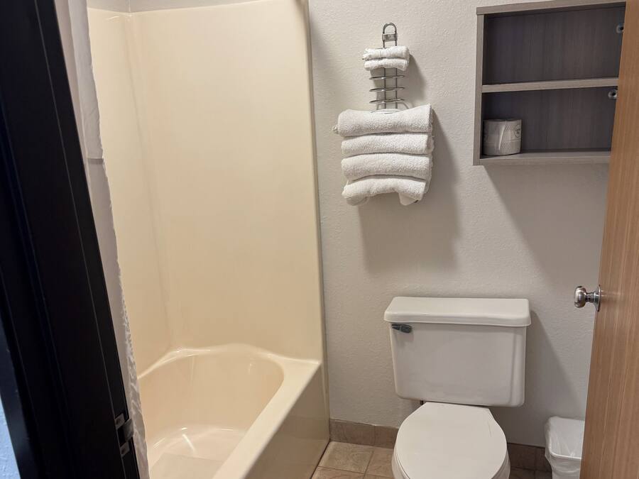 A bathroom with a bathtub, toilet, and a towel rack.