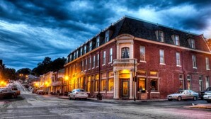 A historic building with a prominent corner entrance, multiple windows, and a brick facade. - Saint George Hotel (Weston)