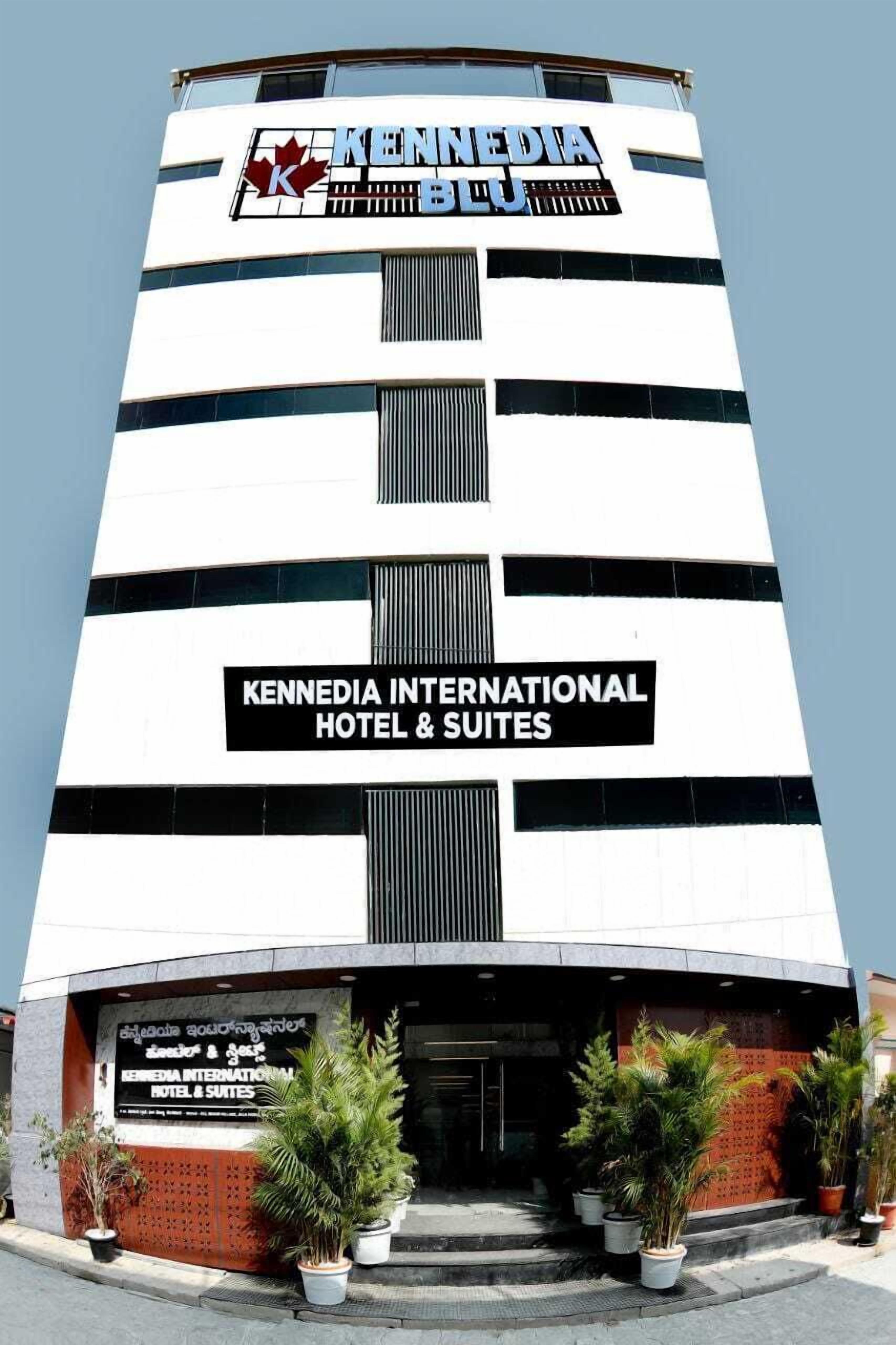 A tall building with the sign "Kennedia International Hotel & Suites" prominently displayed.