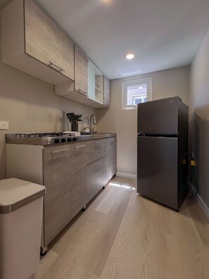 A modern kitchen with a built-in gas stove, stainless steel appliances, and light wood cabinetry. - Amazing 3-Bedroom Beach House 7-min Drive to the Ocean & Palm Trees Up to 8 Ppl (Noord)