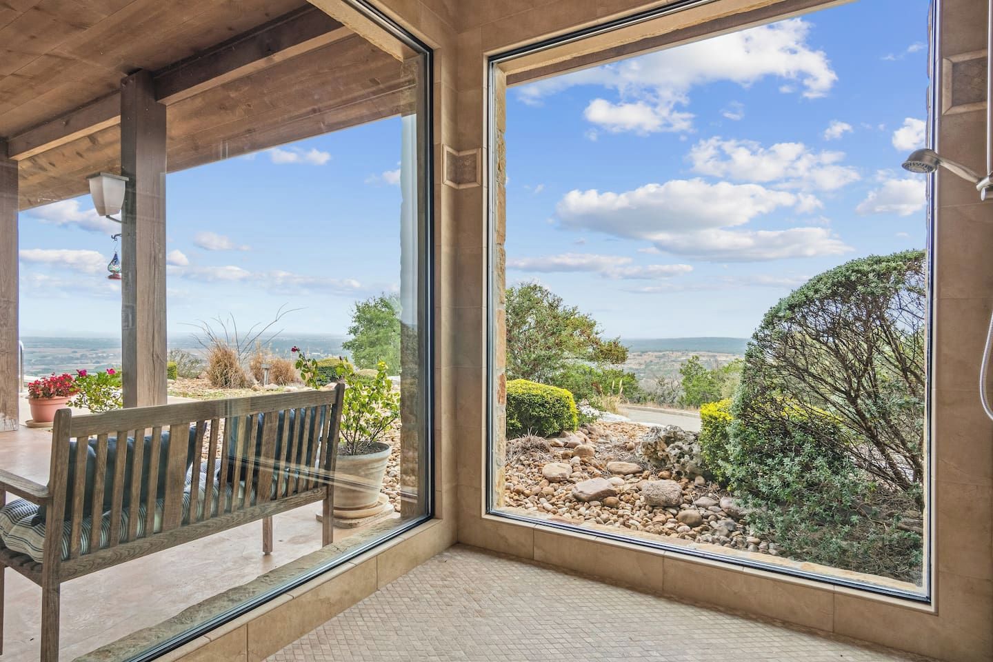Una habitación con un amplio ventanal que da a un paisaje rocoso y una vista distante.