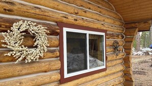 A log cabin with a window and a wreath on the wall. - Tranquil 3 Bedrm house w AC in Seeley Lake, MT-Dogs Allowed-Fenced Yard-Firepit (Seeley Lake)