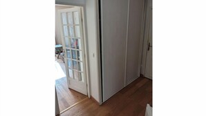 A room with a sliding door, a small table, and a chair. - 2-room apartment Maisons Laffitte/Paris (Maisons-Laffitte)