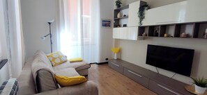 Ein Wohnzimmer mit einer Couch, einem Fernseher und Einbauschränken.