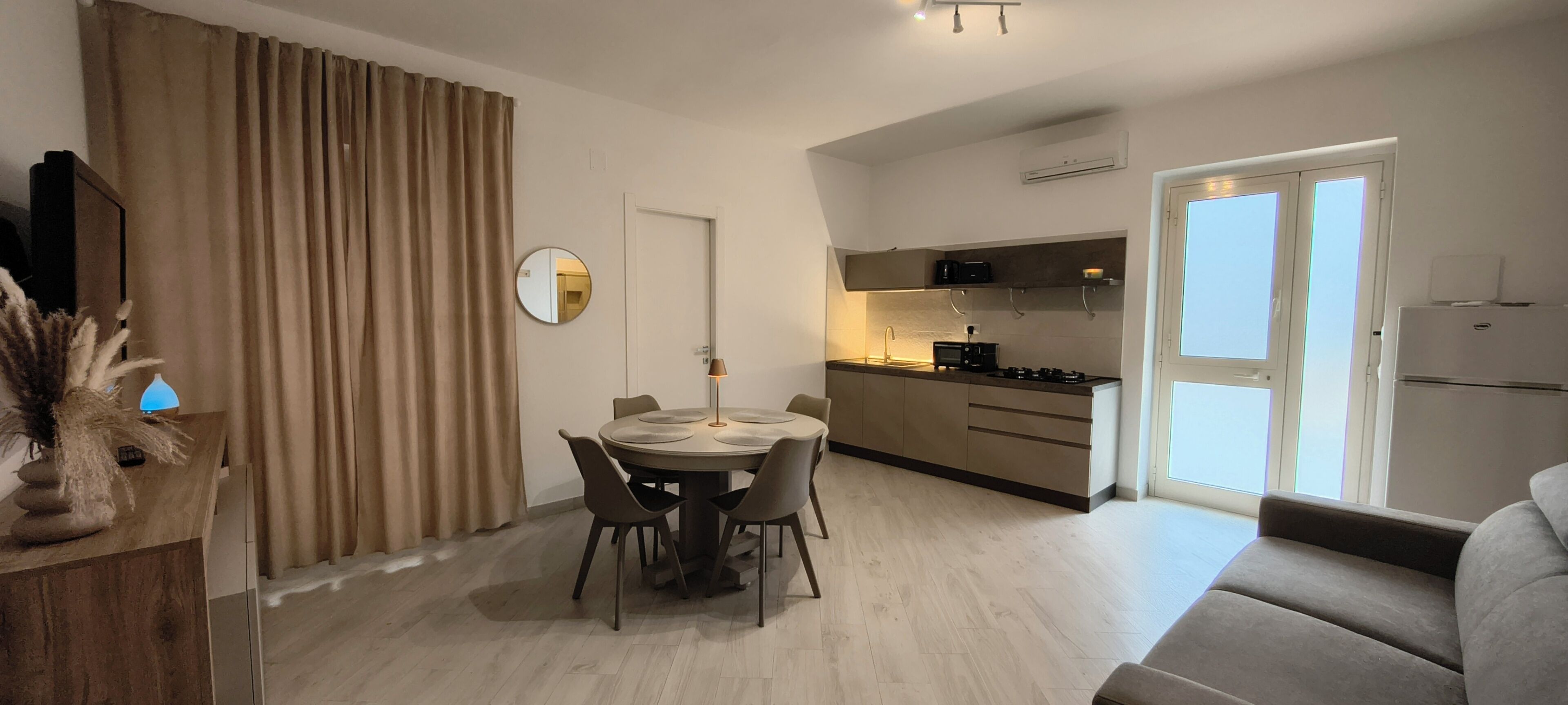 Un appartamento moderno con zona pranzo, cucina e soggiorno.