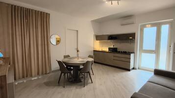 Un appartamento moderno con zona pranzo, cucina e soggiorno.