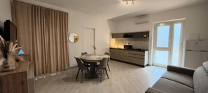 A modern apartment with a dining area, kitchen, and living space. - Spacious apartment in villa with swimming pool (Peschici)