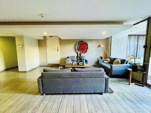 Ein modernes Wohnzimmer mit einem grauen Sofa, einem Couchtisch und einer Kakteenpflanze.
