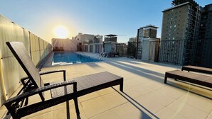 A rooftop pool area with lounge chairs and a view of the cityscape. - Apartment close to Barrio Italia Parking Wifi (Santiago)