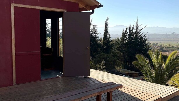 A wooden deck with a red building in the background.