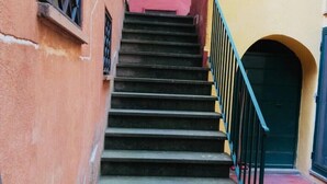 A set of outdoor stairs leading to a building entrance with a blue door and a small window with a metal grille. - Lovely one-bedroom apartment historic center of Tuscania within walking distance of the Municipal Theater. (Tuscania)