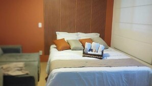 A hotel room with a bed, a small sofa, and a bedside table. - Apartment in the Rio Wonder Condominium - Downtown Rio de Janeiro. Close to EVERYTHING. (Rio de Janeiro)
